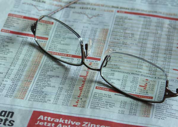 glasses resting on financial newspaper