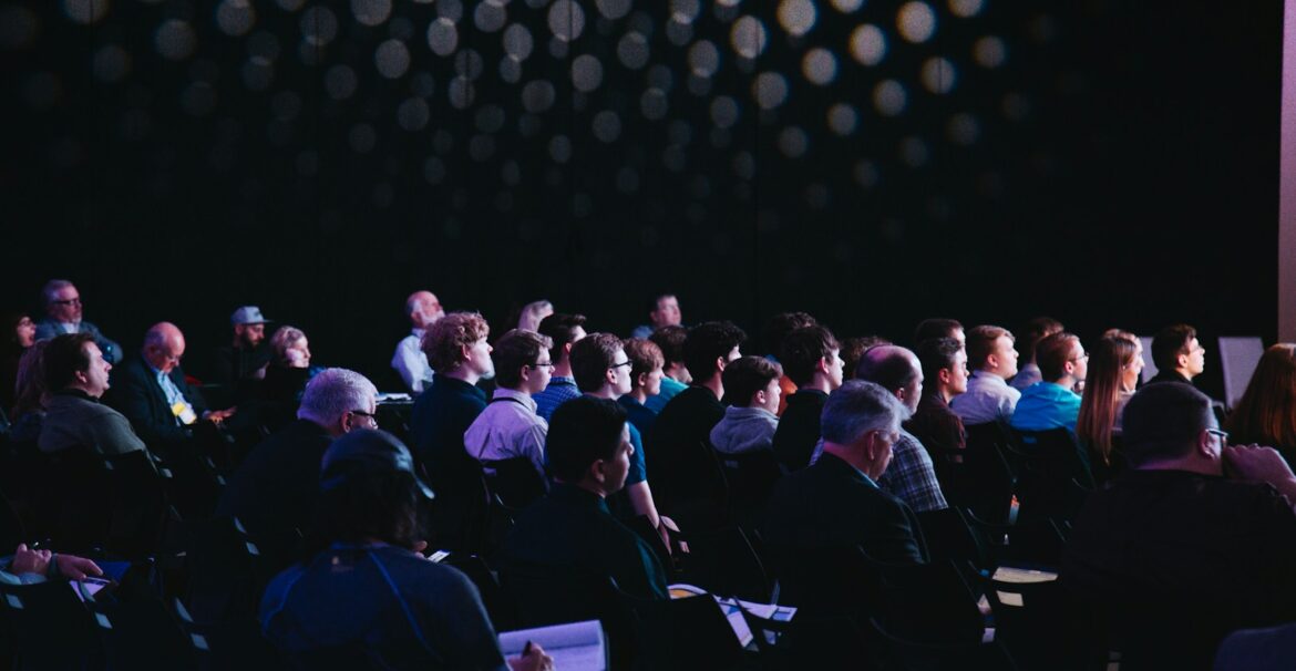 crowd of people sitting on chairs inside room