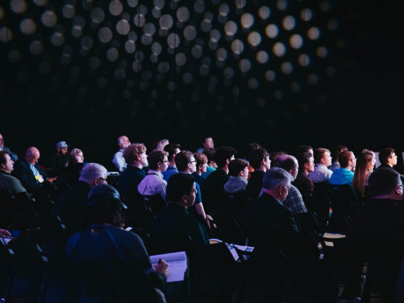 crowd of people sitting on chairs inside room