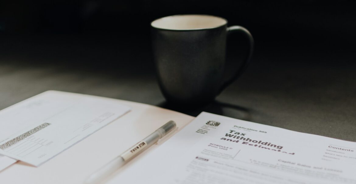 coffee mug near open folder with tax withholding paper